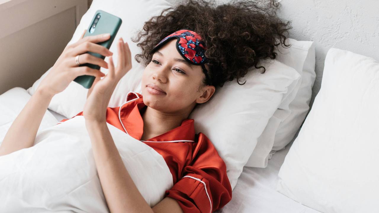 žena ležiaca v posteli s mobilom v ruke